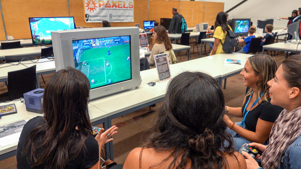 Quatre visiteurs jouent à Mario Smash Football (2005) sur GameCube durant la Nuit des Musées 2019 au Musée Bolo