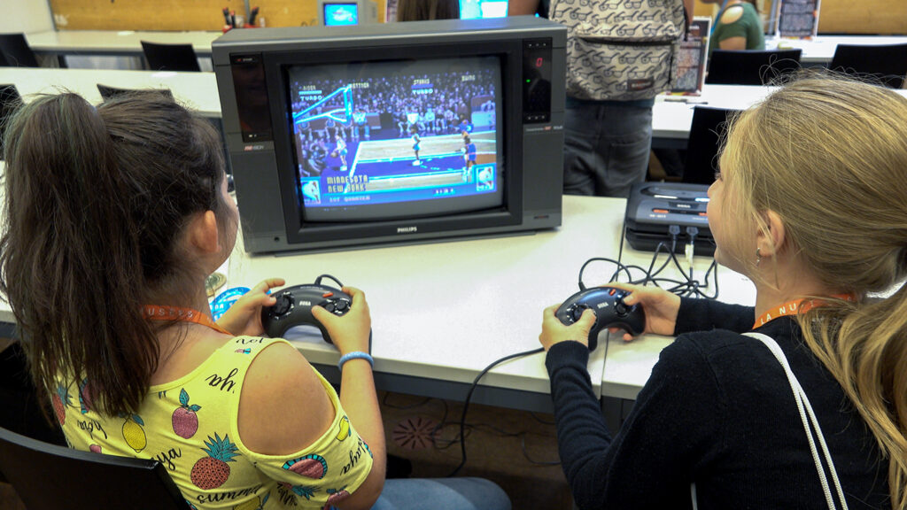 Deux visiteurs jouent à NBA Jam (1994) sur MEGA-CD pendant la Nuit des Musées 2019 au Musée Bolo