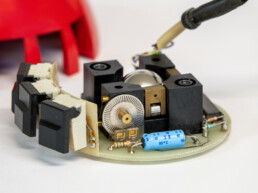 Intérieur de la souris 4 fabriquée par Dépraz. Au premier plan, un capteur incrémental («roue à rainures») devant lequel se trouvent deux diodes électroluminescentes infrarouges | © Musée Bolo
