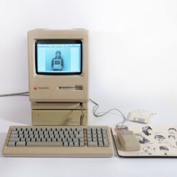 Marielle Stamm dans le Macintosh Plus, le premier ordinateur à pénétrer physiquement dans la salle de rédaction d’Informatique & Bureautique en 1987. Il transforma en profondeur la manière de travailler de la pionnière du journalisme en informatique et d’autres acteurs de la presse | © Musée Bolo